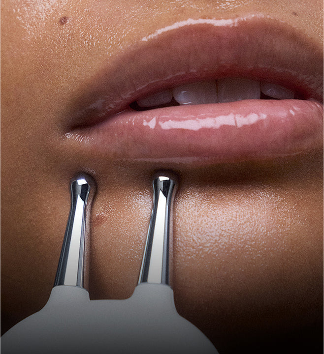 Woman using microcurrent device on cheek